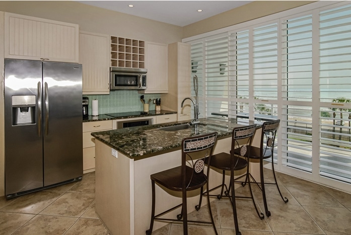 Photo of kitchen with breakfast bar and view of Gulf of Mexico through the window at Diamond Beach Condominiums