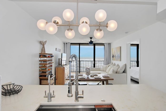 Photo of living room from kitchen with Gulf view in background at Riviera II Condominiums.