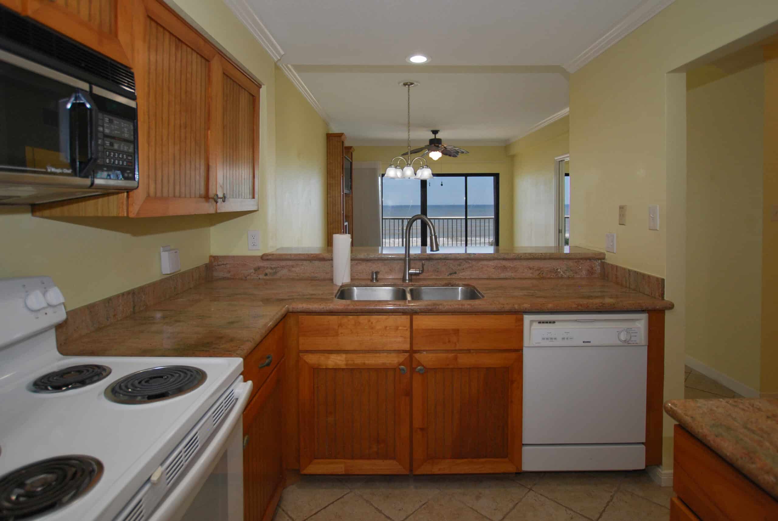 Photo of kitchen looking out toward living/dining room with view of Gulf.