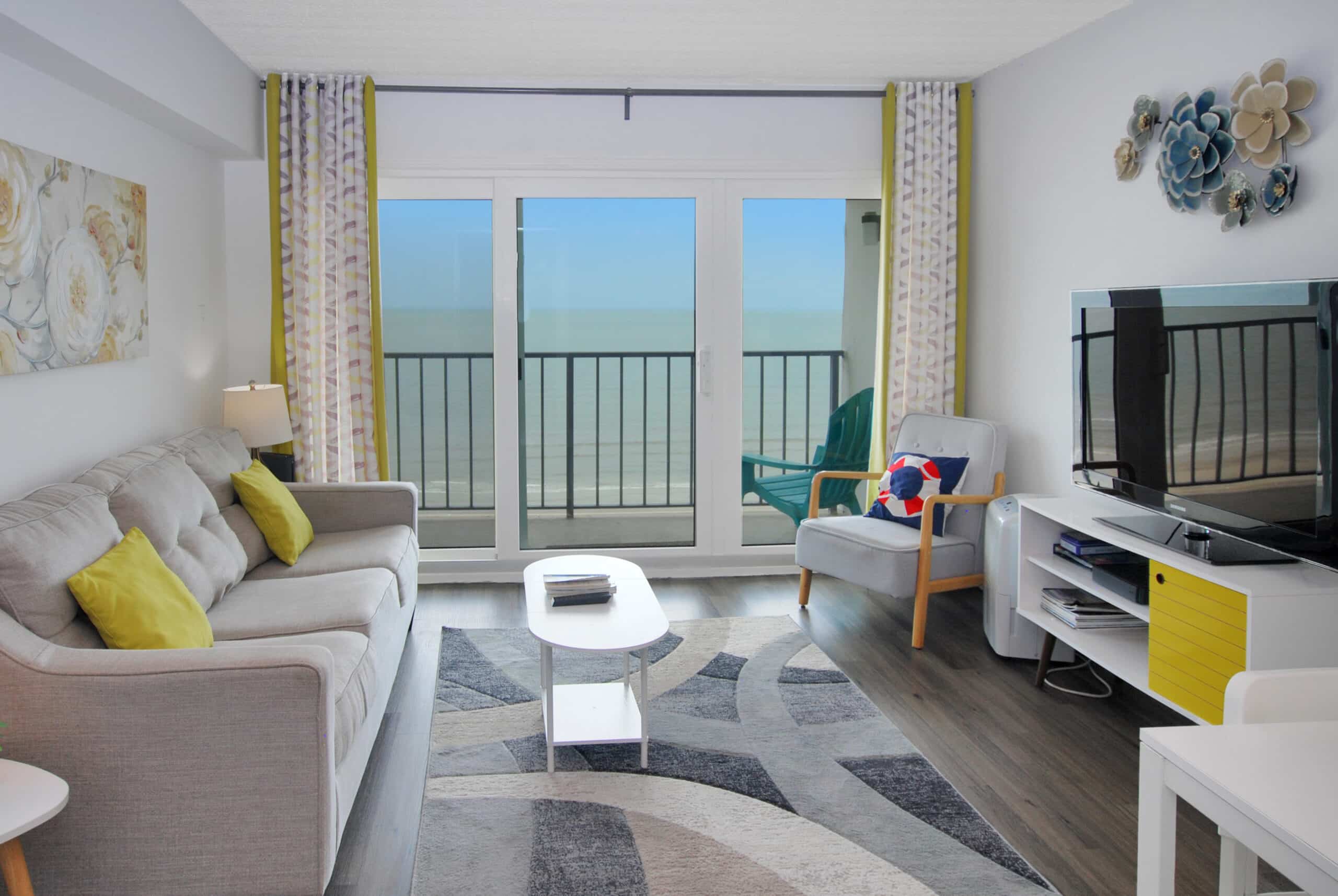 Photo of living room with Gulf view through window at By The Sea Condominiums