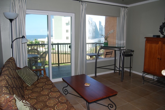 Photo of living room with view of balcony and Gulf through the window at Maravilla Condominiums