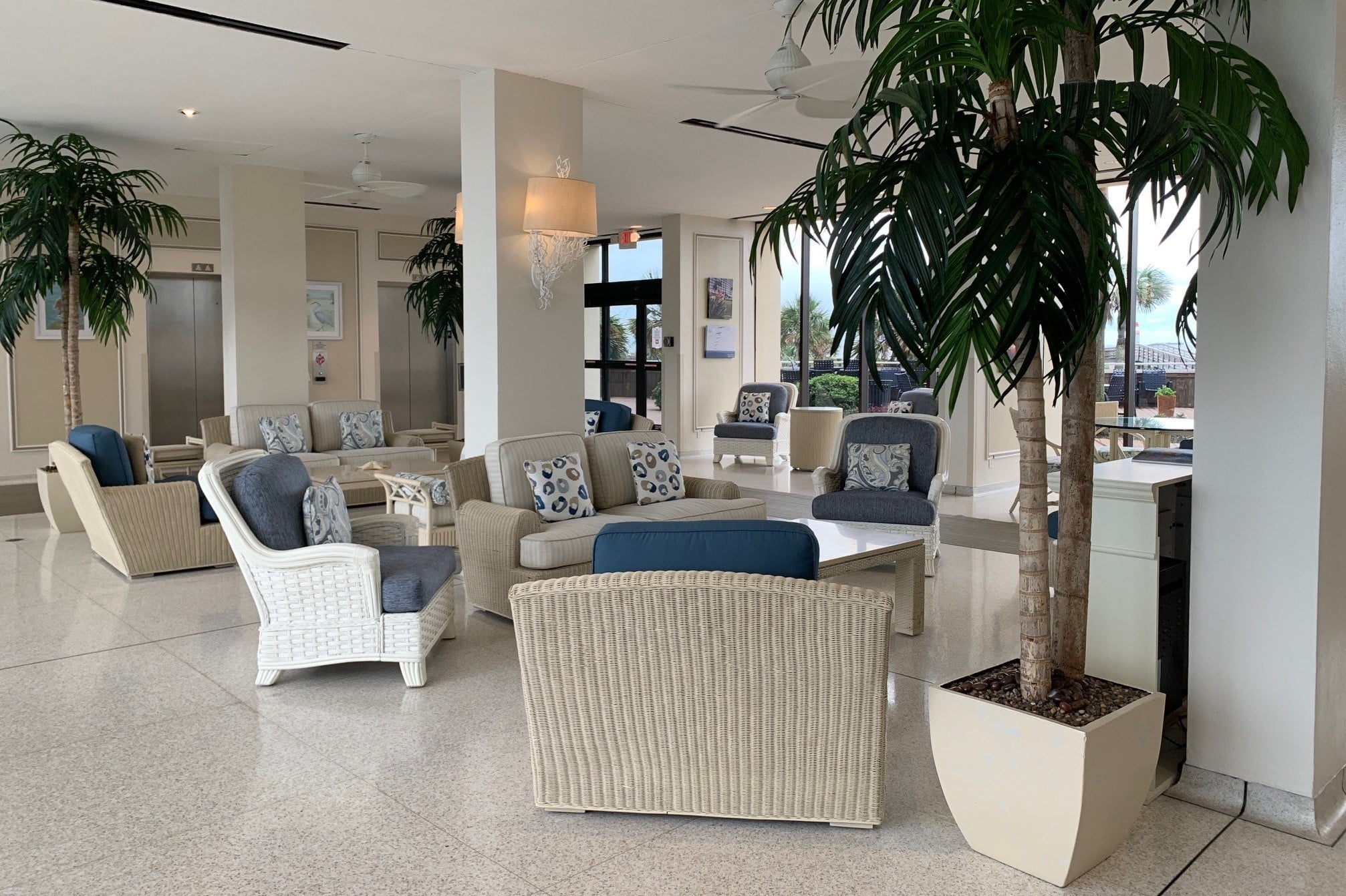 Photo of lobby of Galvestonian Condominiums showing chairs and palms