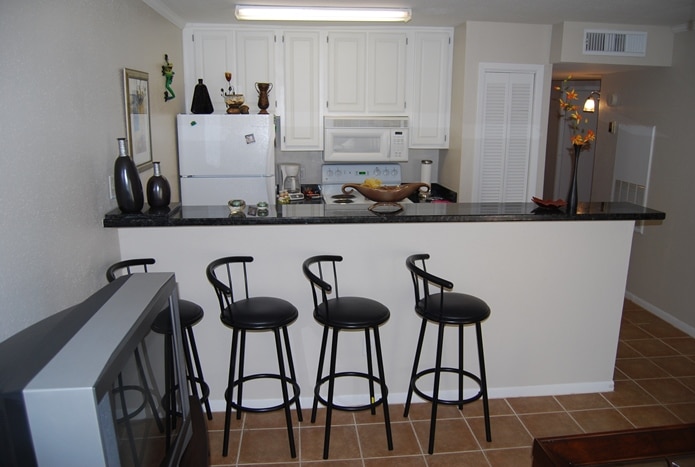 Photo of kitchen with breakfast bar and barstools at Maravilla Condominiums