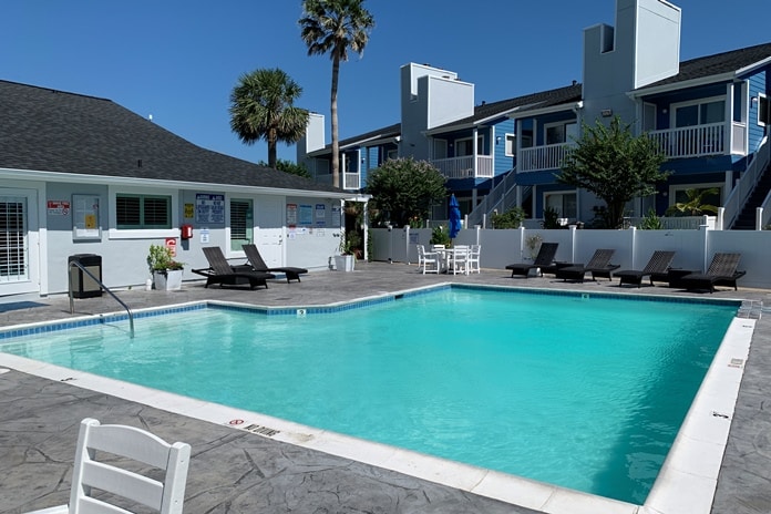 Photo of swimming pool and clubhouse at Palms At Cove View Condominiums