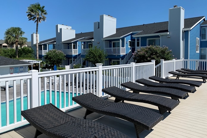 Photo of sundeck with pool and building in background at Palms At Cove View Condominiums