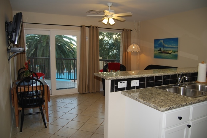 Photo of living room with view of balcony and pool through window at Maravilla Condominiums