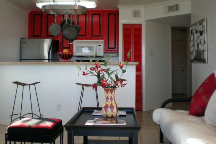 Photo of kitchen and living room area with red and black decor at Maravilla Condominiums