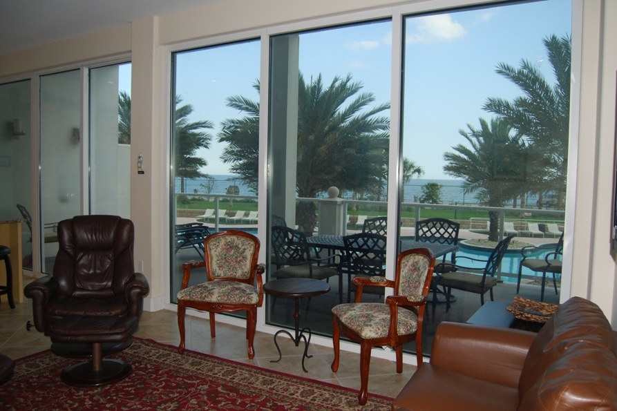 Photo of living room with view of pool from balcony at Diamond Beach Condominiums