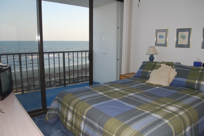 Photo of bedroom with view of beachfront through windows at West Beach Grand Condominiums