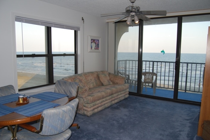 Photo of living room with view of Gulf through windows at West Beach Grand Condominiums